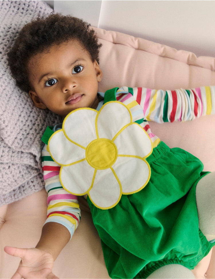 Baby facing the camera laying down wearing full boden outfit