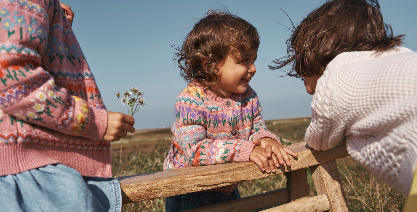 Three girls together two wearing matching Boden Fair Isle cardigans.