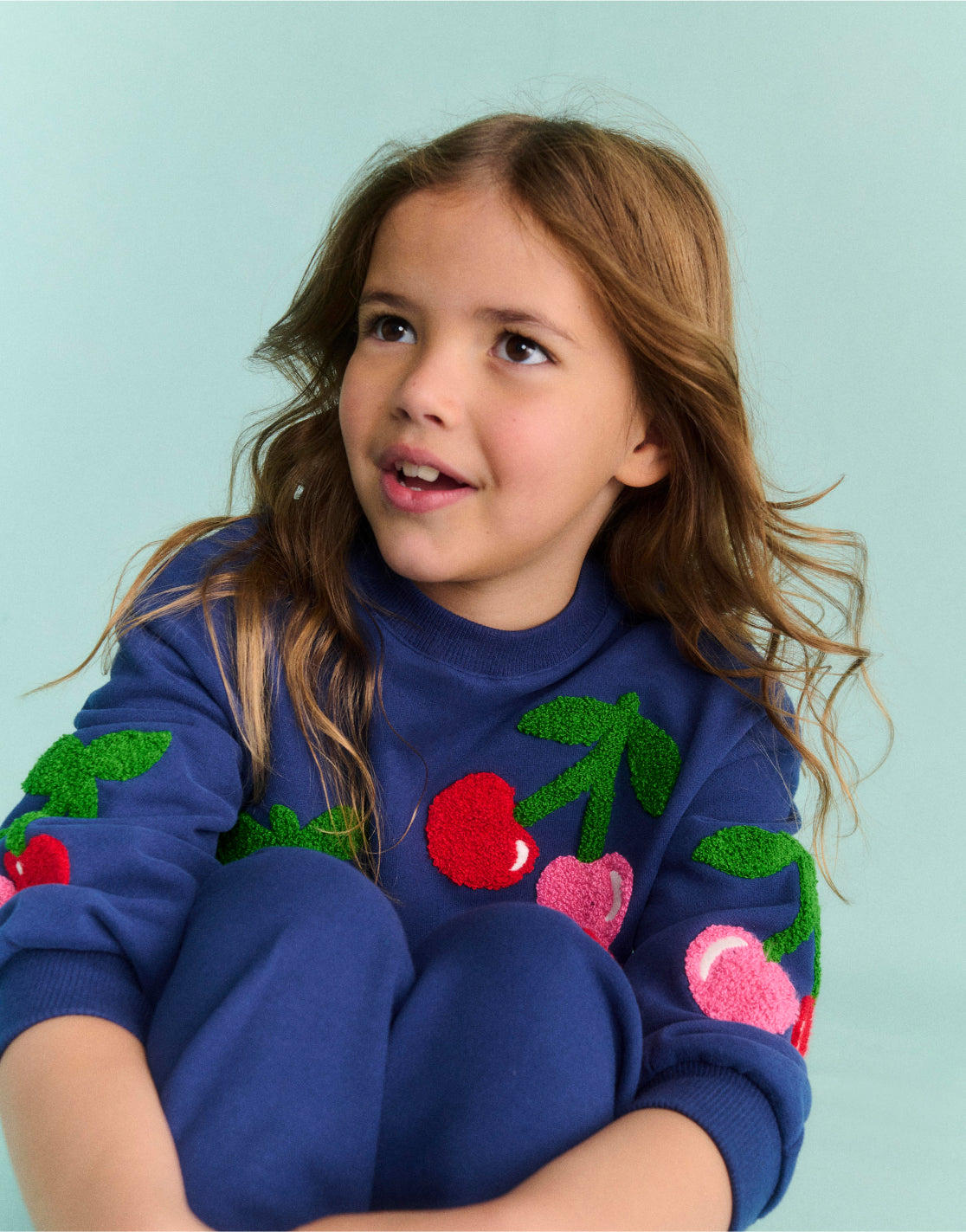 Girl wearing a sweatshirt with Cherries Print