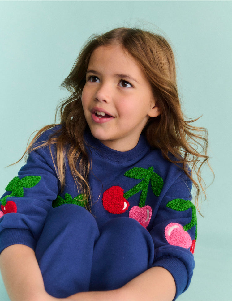 Girl wearing a sweatshirt with Cherries Print