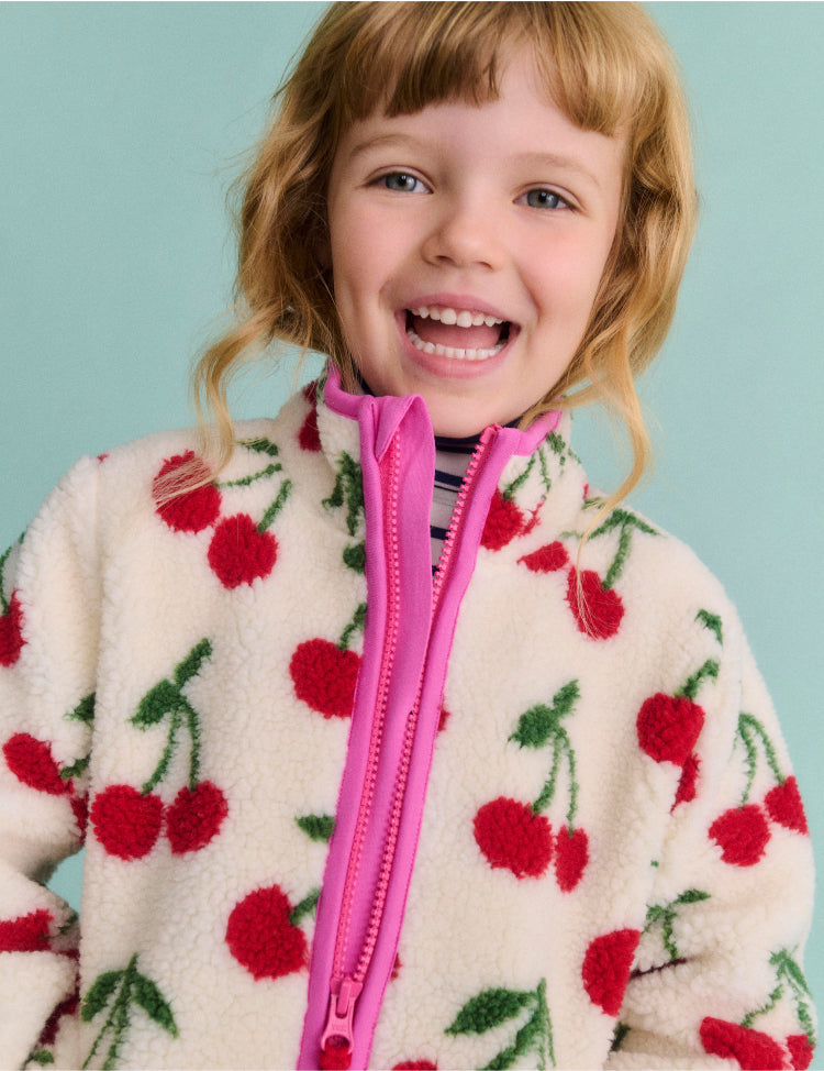 Girl wearing a Boden Jacket with cherries print