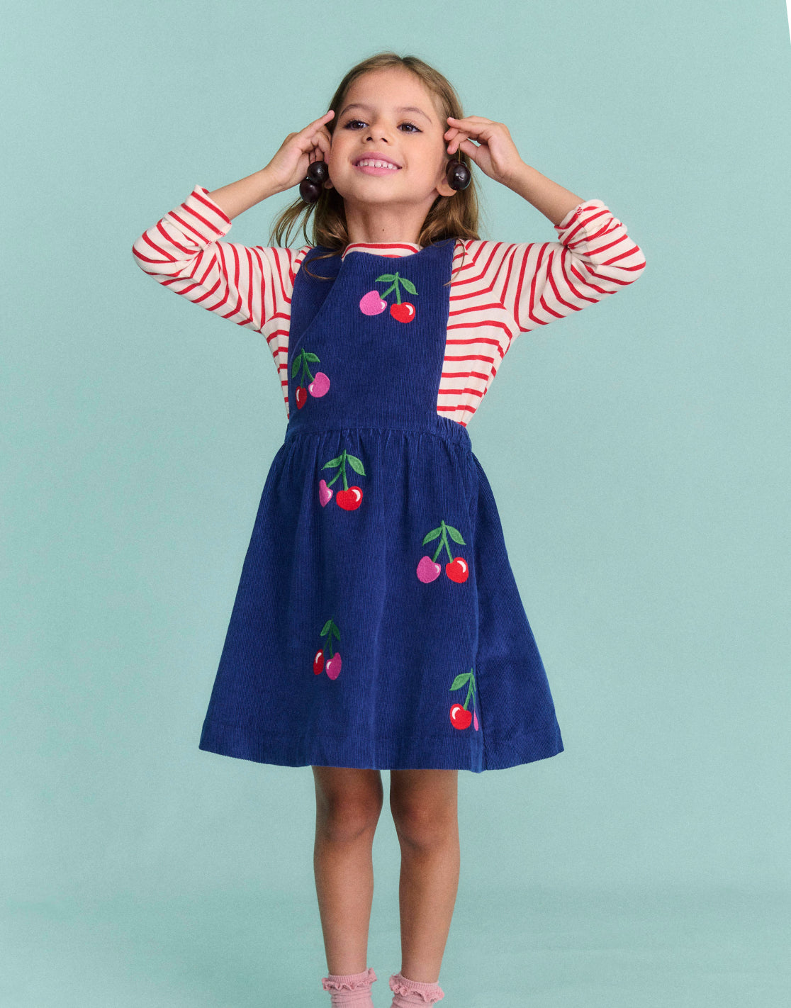 Girl wearing a Boden dress with Cherries print