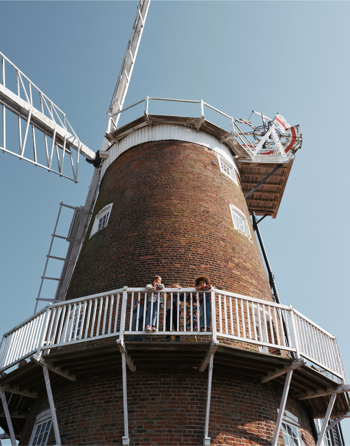 Children standing together on the balcony of a windmill 