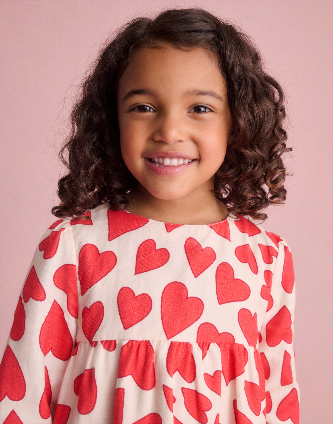 Girl wearing a Boden dress with Poppy Red Hearts