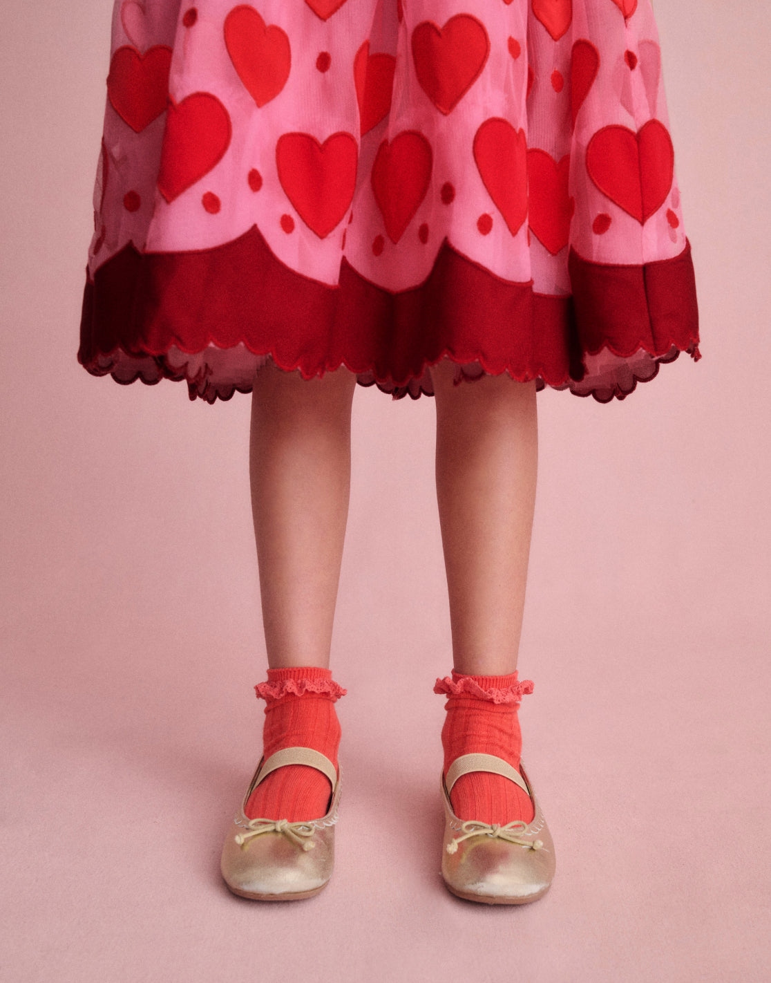 Girl wearing a Boden dress with Pink Hearts